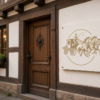 Wandschild Pferdekutsche als Außenschild an einem Fachwerkgebäude